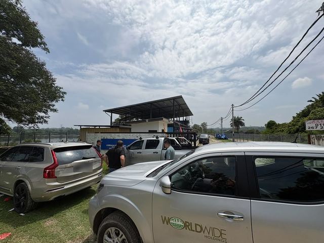 Vehicles parked on site, one with the Worldwide Holdings logo