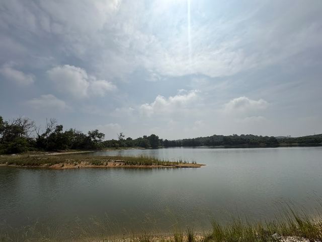 A low, grassy island in the lake under a cloudy sky